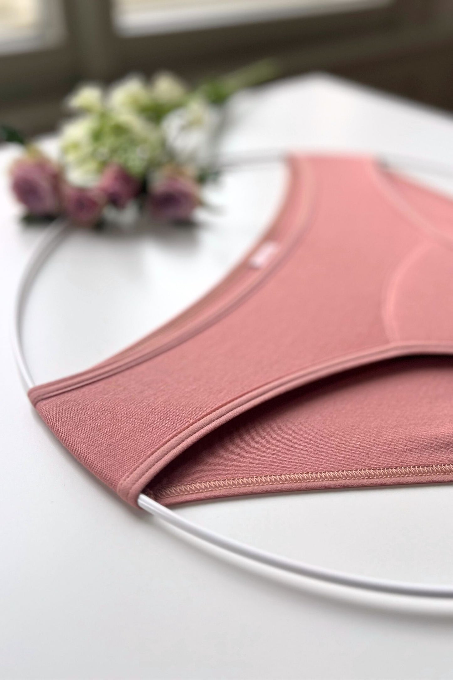 Detail na švy menstruačních SAYU kalhotek, foceno na bílém pozadí.