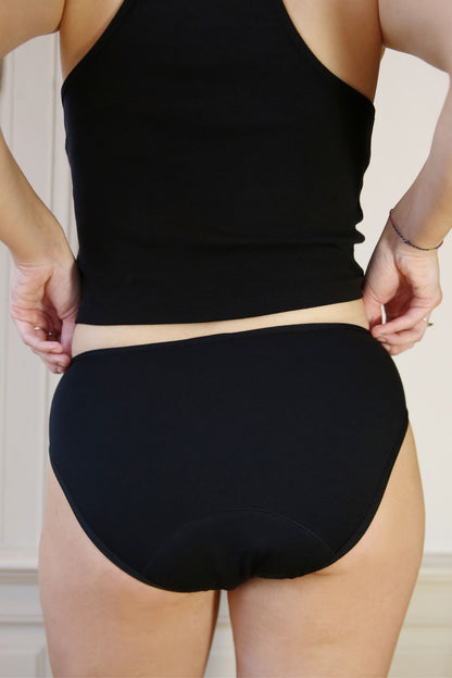 Černé menstruační kalhotky v klasickém střihu - pohled zezadu na modelce