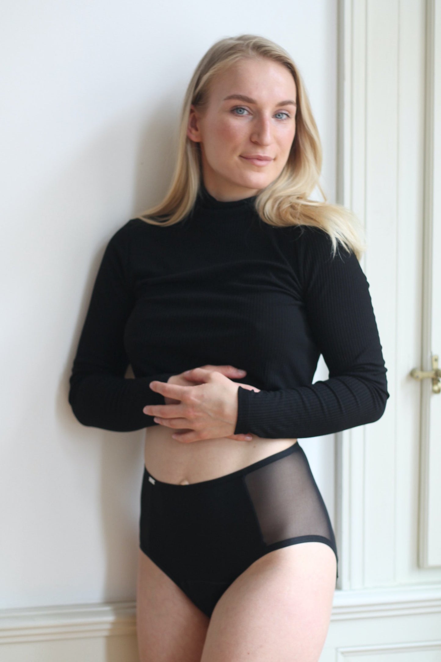 Přední pohled na černé pasové menstruační kalhotky střední savosti na modelce