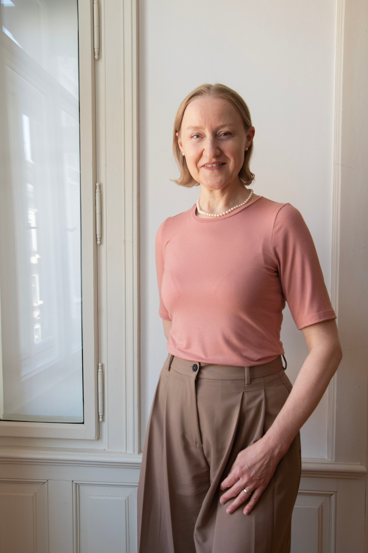 Moderní tričko v barvě růžové latte s krátkým rukávem v minimalistickém designu. Přední pohled na elegantní střih, který podtrhuje štíhlou siluetu, zatímco ultraploché švy zajišťují komfort a jemnost při nošení.