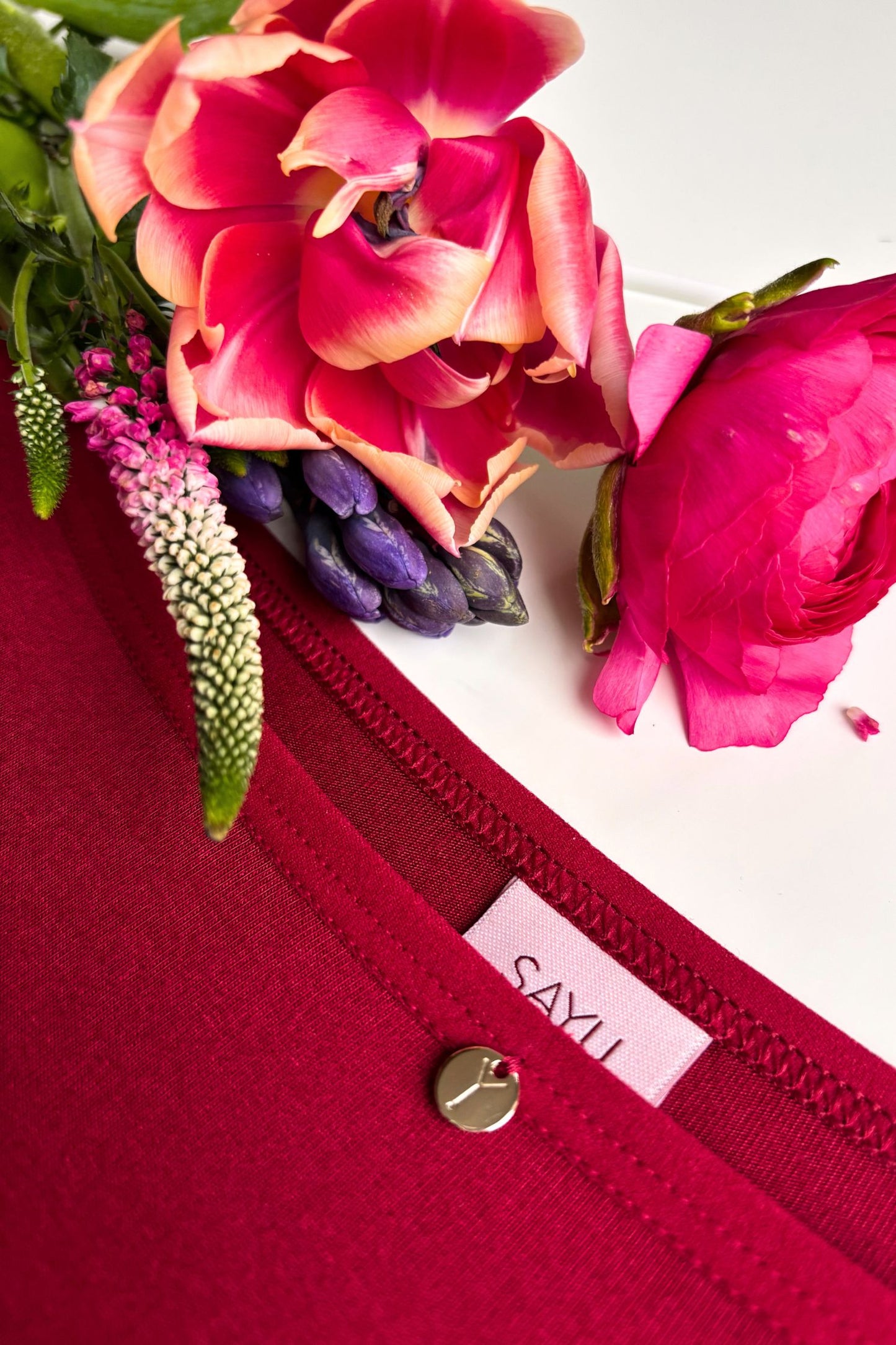 detailní pohled na přední díl funkčních kalhotek SAYU s kulatým zlatým zdobným prvkem