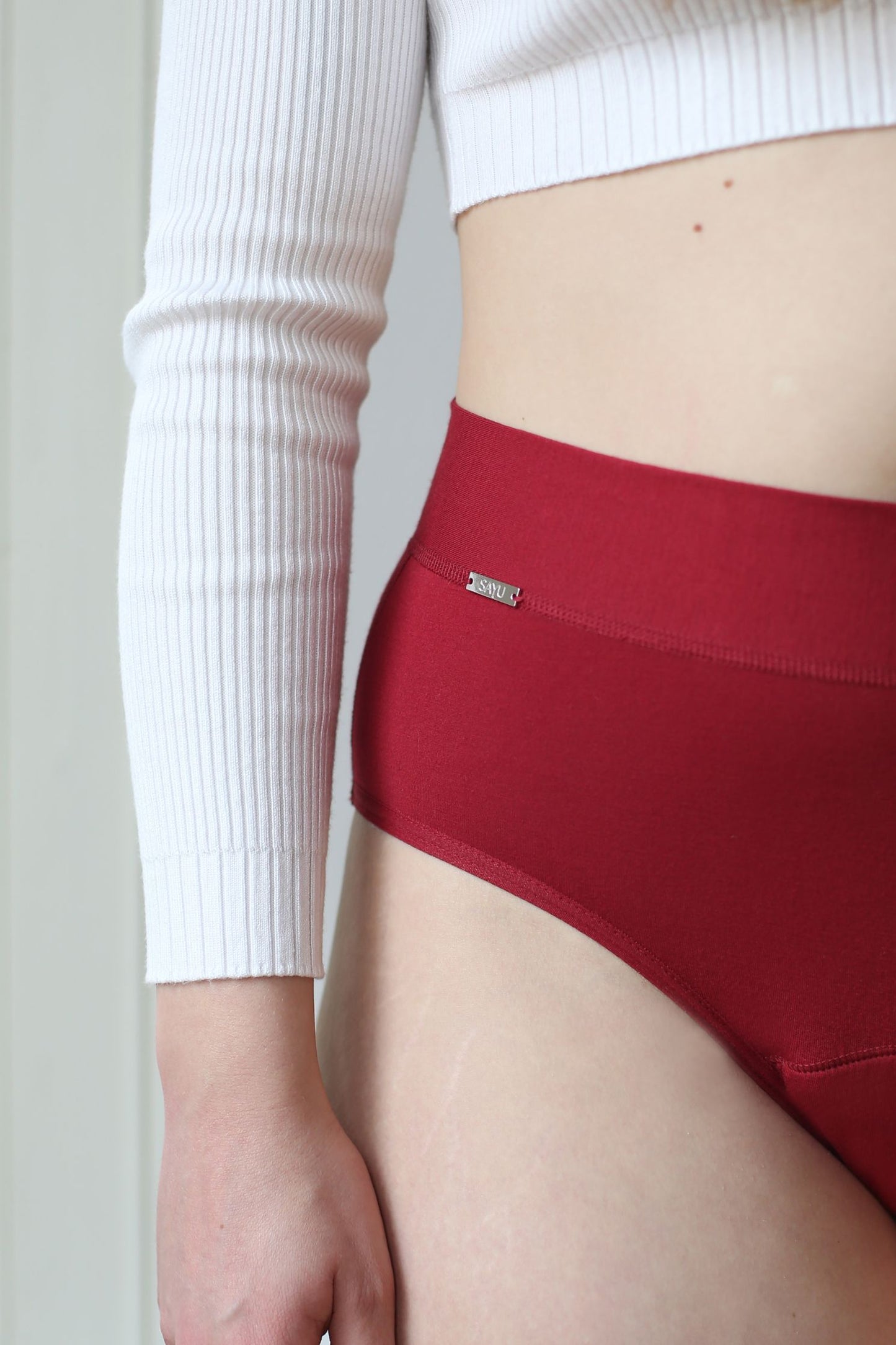 detail na zdobný prvek na menstruačních bordó kalhotkách na spaní s logem SAYU