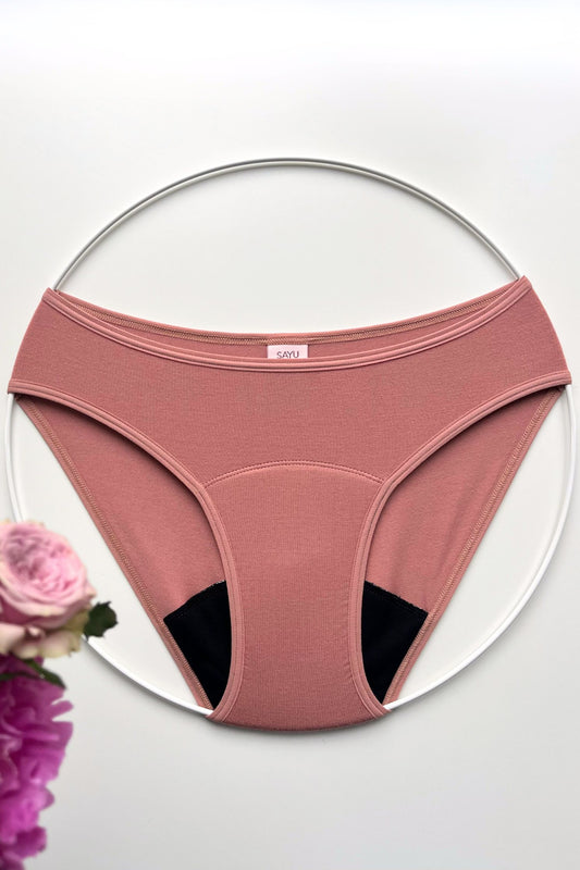 Menstruační kalhotky klasického střihu a nízké savosti v barvě růžové latte, foceno na bílém pozadí.
