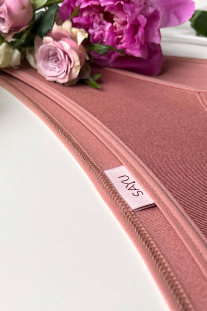 Detail na švy a etiketu menstruačních kalhotek klasického střihu v barvě růžové latte.