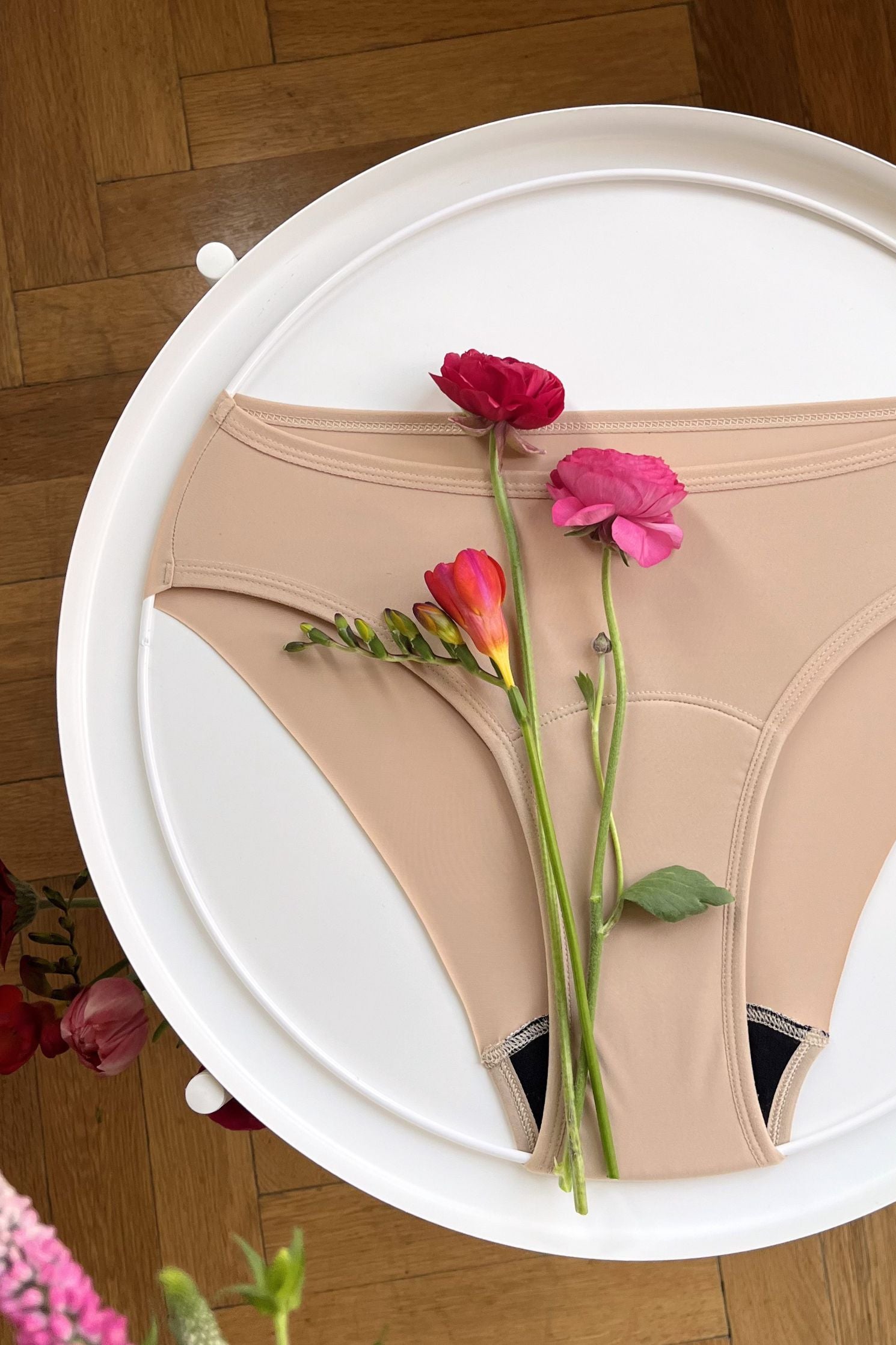 Pohled shora na přední část bezešvých menstruačních kalhotek s hladce řezaným okrajem na zadní straně. 