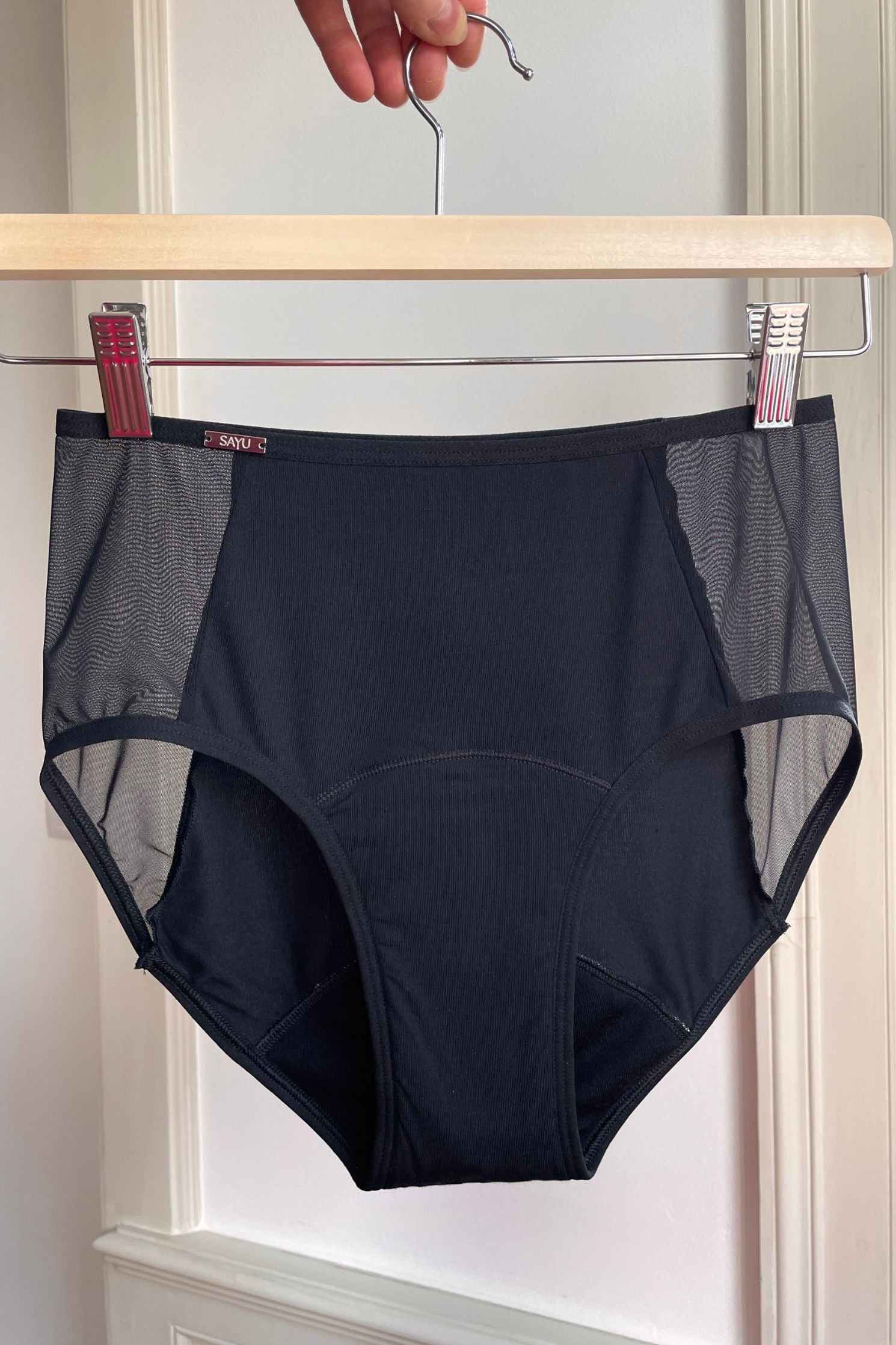 Produktová fotografie černých menstruačních kalhotek s transparentními boky