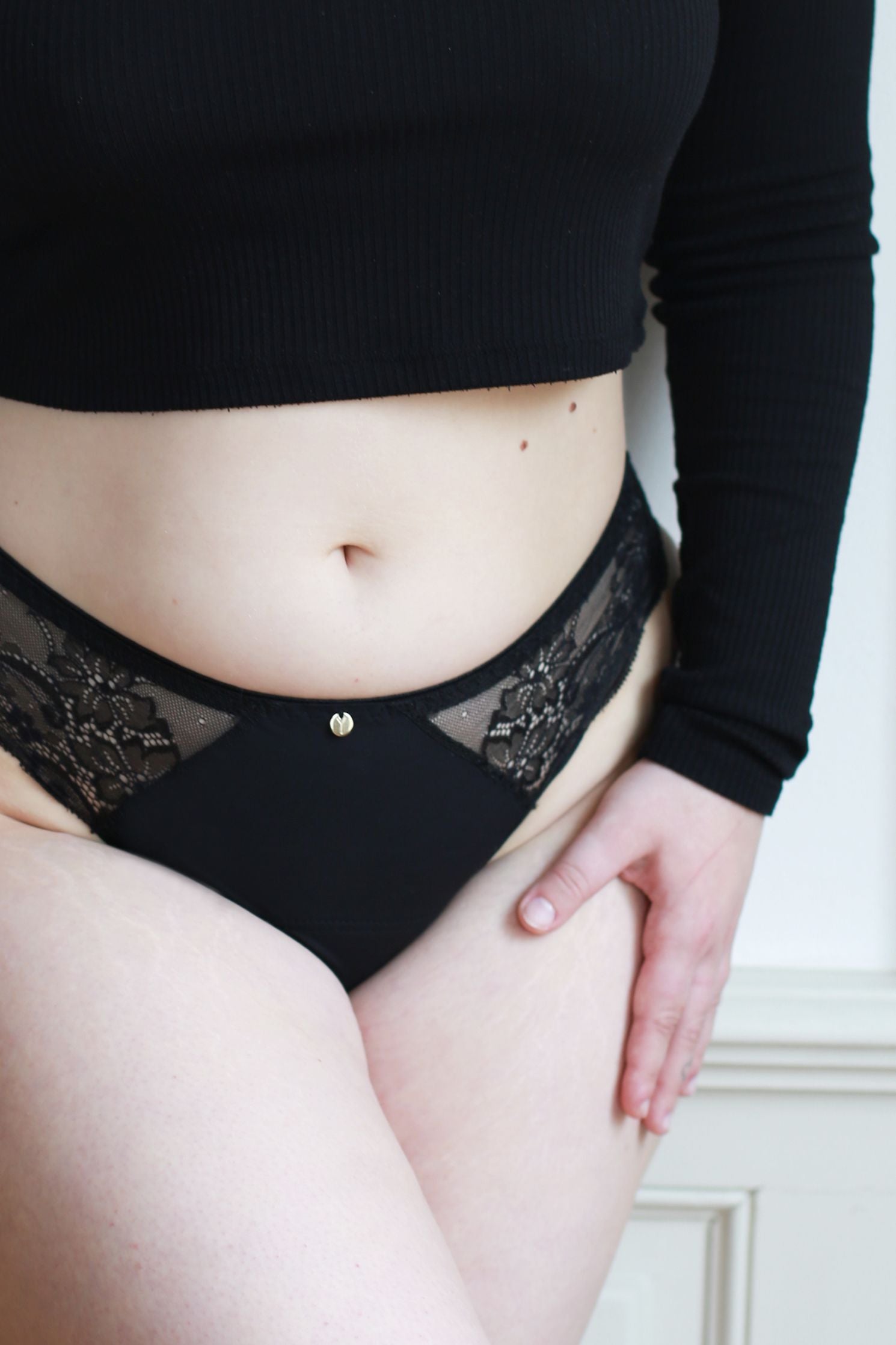 Černé menstruační kalhotky střední savosti s krajkou a prodlouženou vložkou v přední části.