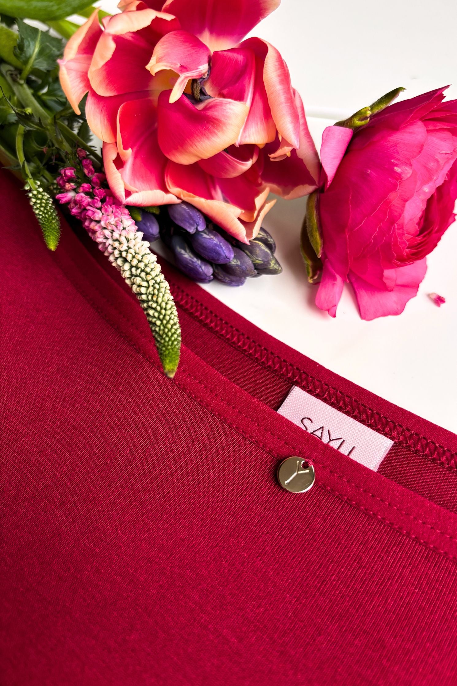 detailní pohled na kulatý zdobný prvek a precizní ušití menstruačních kalhotek SAYU, produktová fotka