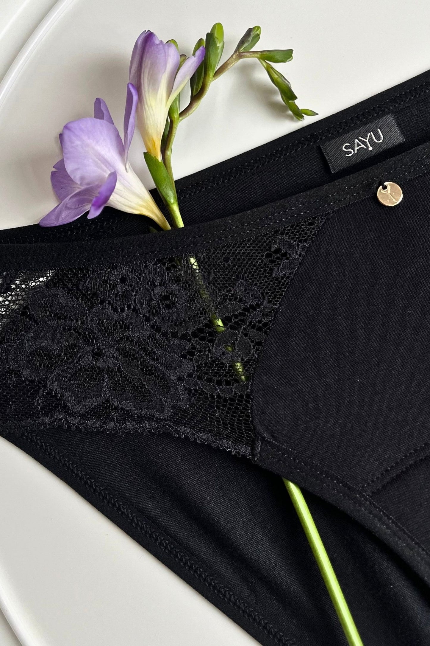 Detail na černou krajku a zdobný prvek černých menstruačních kalhotek SAYU.