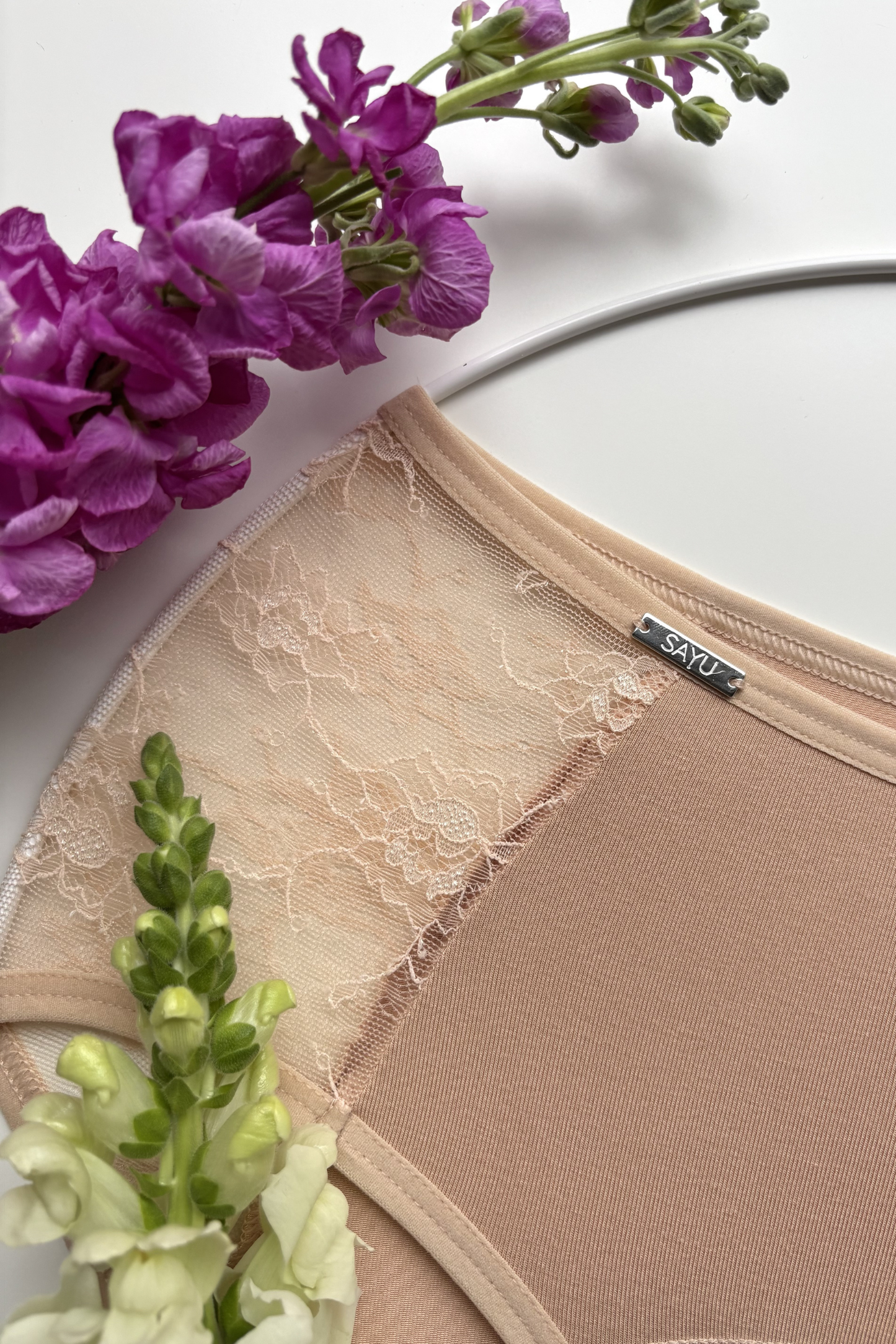 detailní pohled na jemnou krajku bočních vsadek menstruačních kalhotek vyššího střihu v tělové barvě