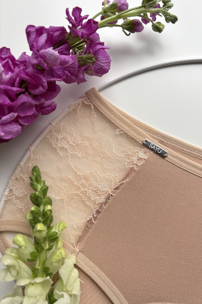 detailní pohled na jemnou krajku bočních vsadek menstruačních kalhotek vyššího střihu v tělové barvě