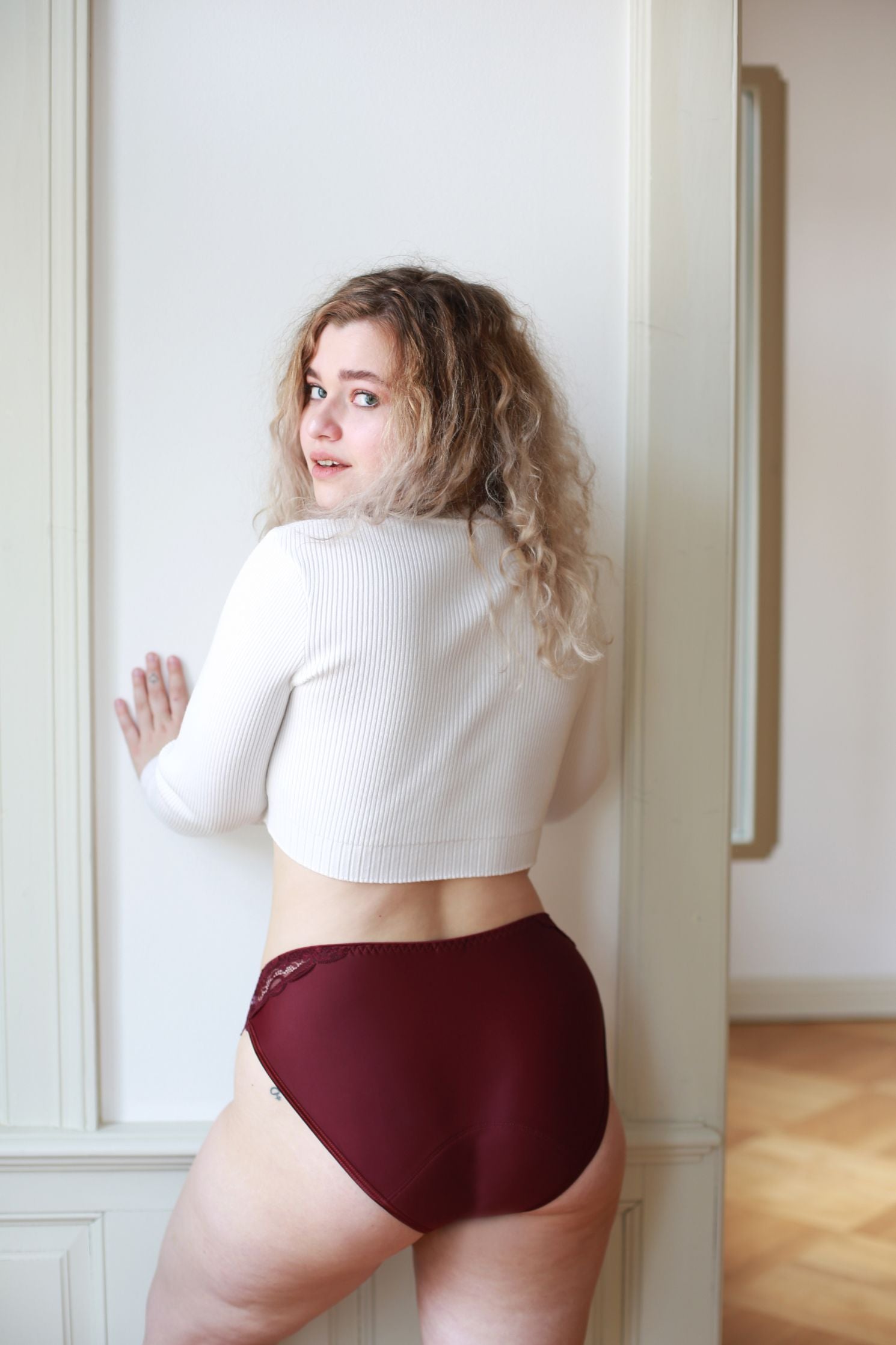 Modelka prezentuje střih menstruačních kalhotek na zadní straně.